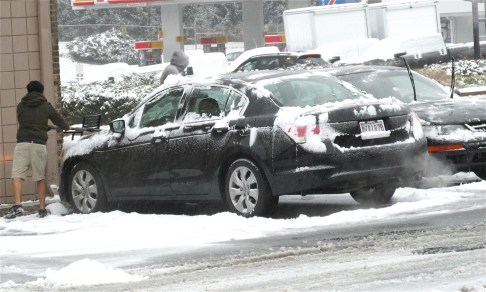 Man wearing shorts clearing snow from car, Gaithersburg, MD Man wearing shorts clearing snow from car, Gaithersburg, MD