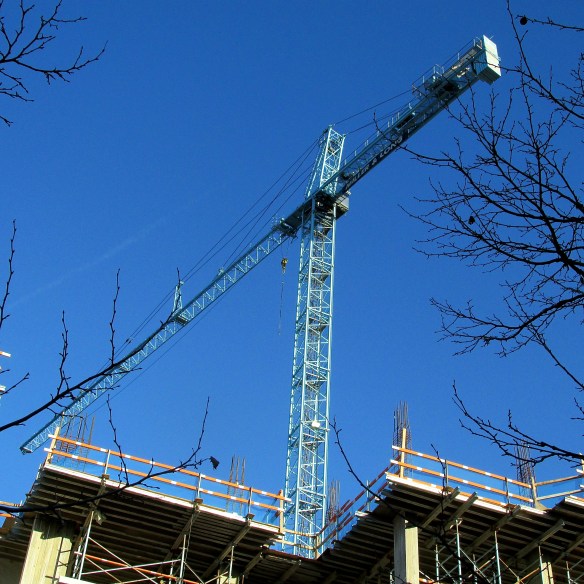 A CONSTRUCTION CRANE TOWERS OVER A BUILDING IN PROGRESS IN THE HEART OF ROCKVILLE.